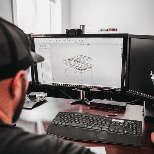 Person designing prototype model for manufacturing on desktop