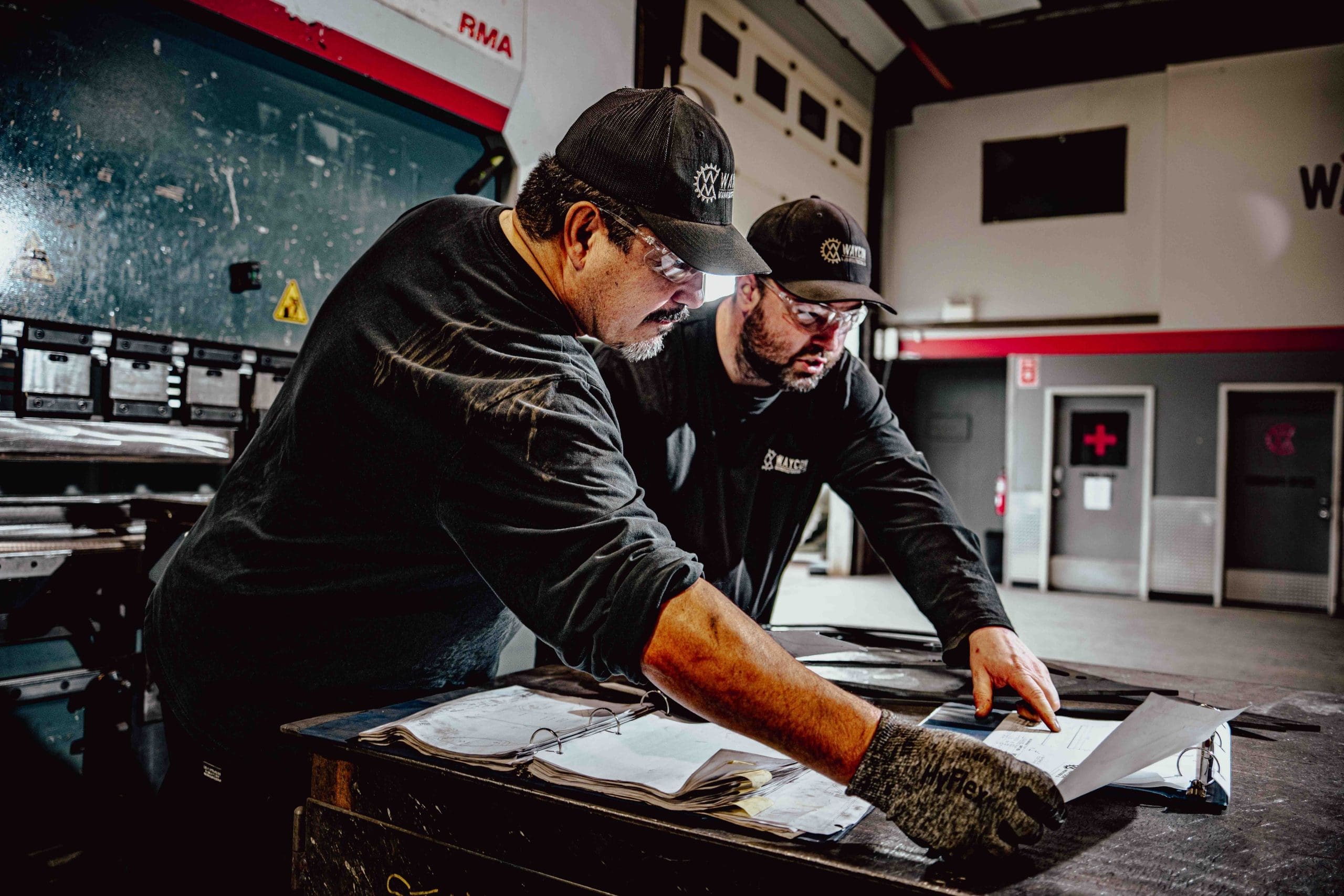 Two workers review the OEM Manufacturing paperwork